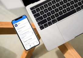 The 1Password application as seen on a mobile device next to a computer