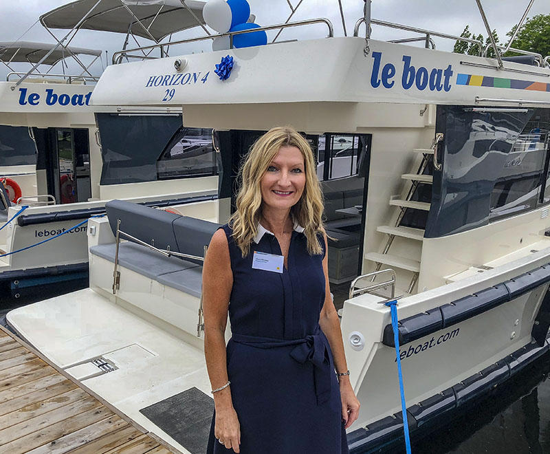 Cheryl Brown standing on a dock with Le Boat yachts behind her.